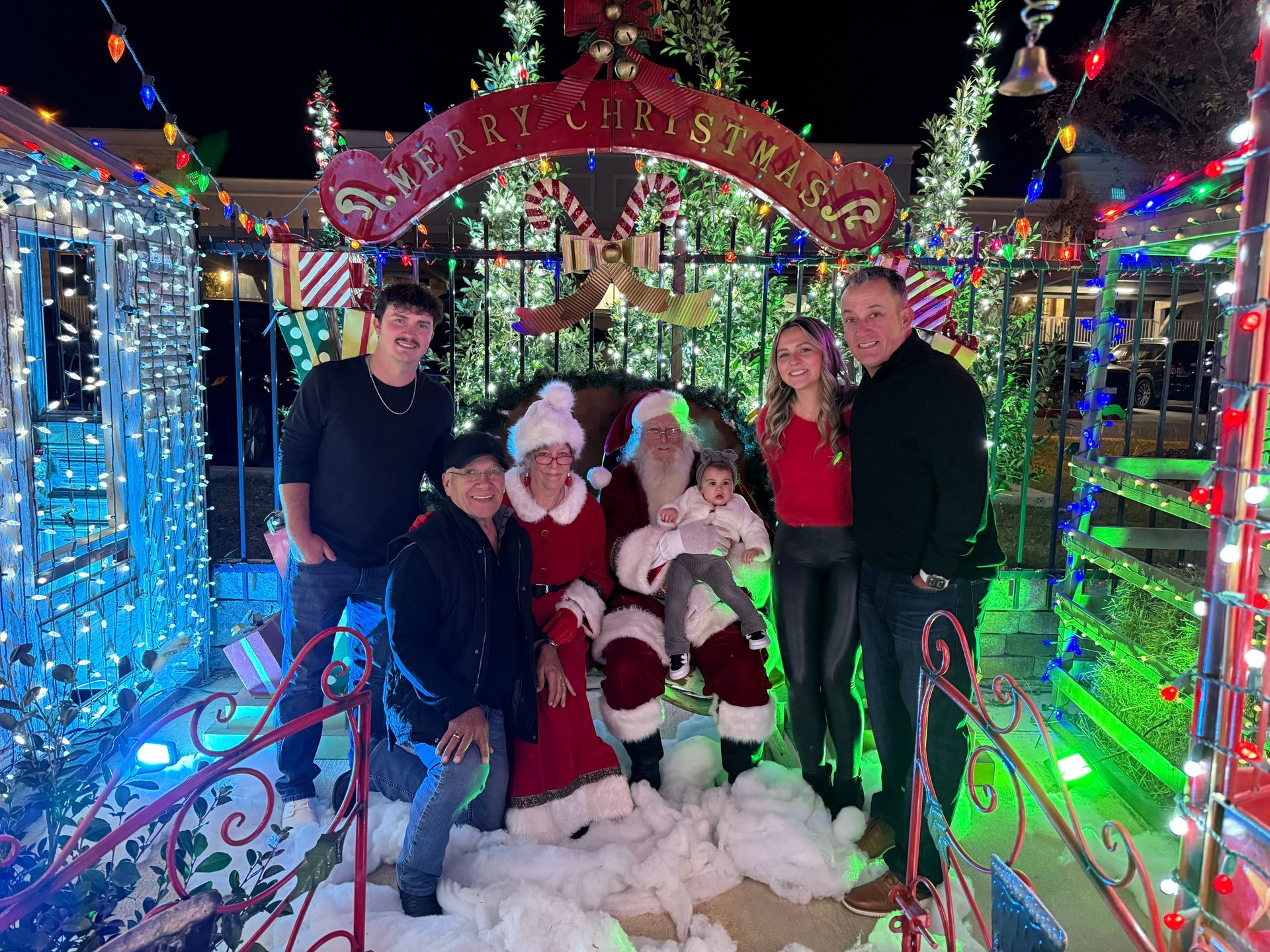 A multi-generational family photo with Santa and Mrs. Claus