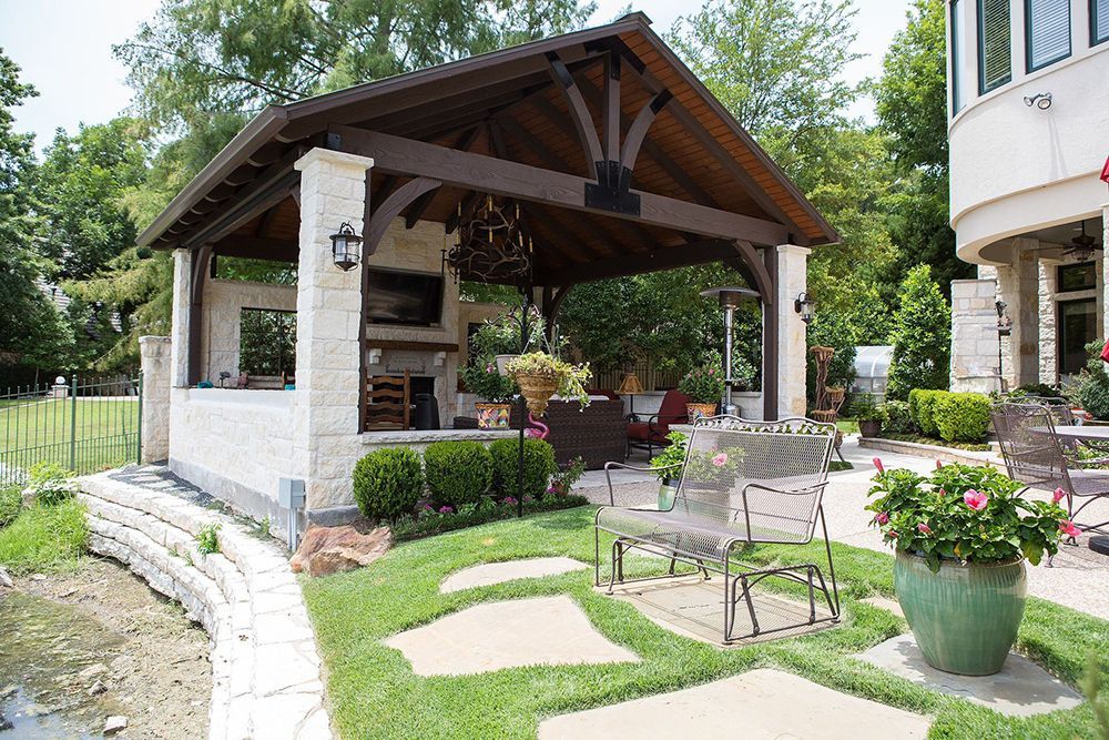 a pergola with a fireplace in the backyard