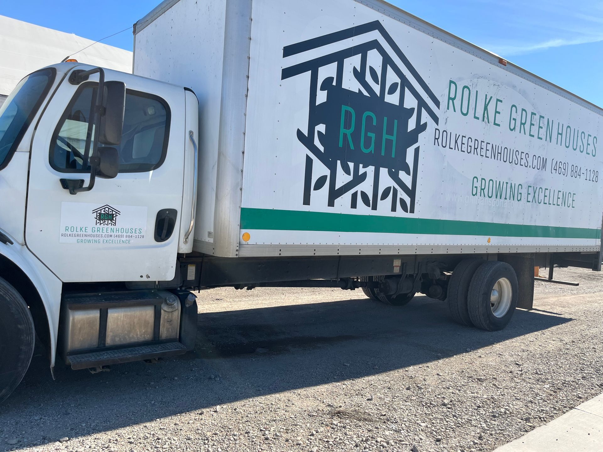White box truck with Rolke Green Houses logo parked outdoors on gravel.