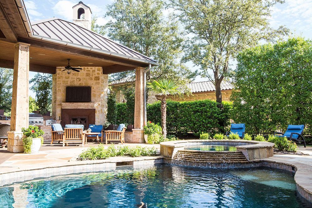 There is a large swimming pool in the backyard of a house