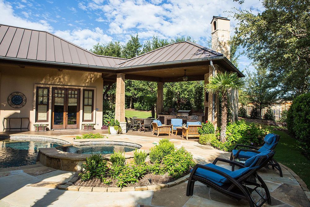 A large house with a covered patio and a pool in the backyard