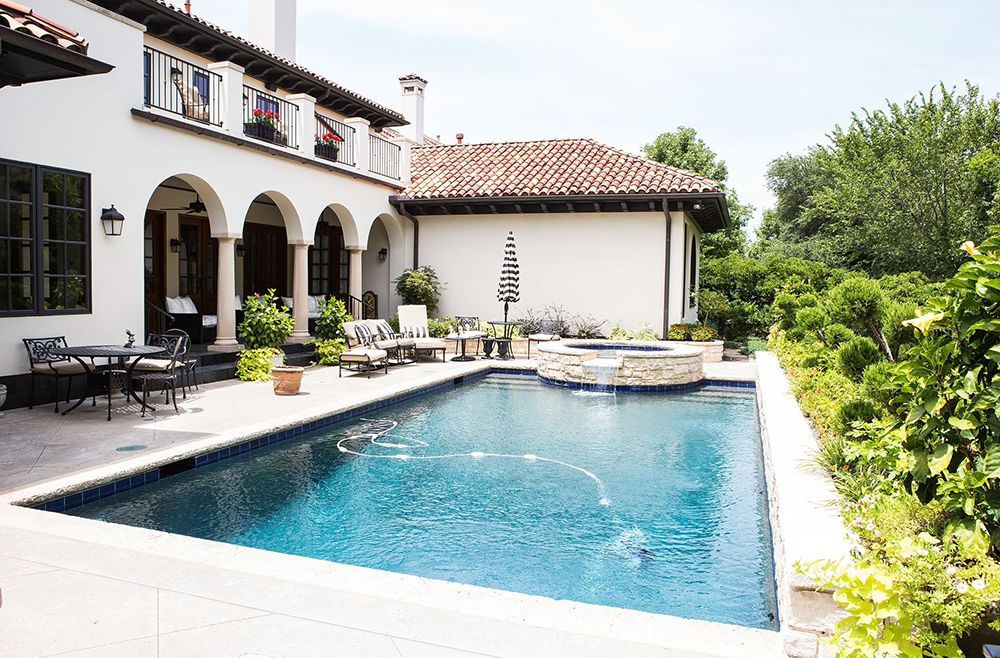 A large white house with a large swimming pool in front of it