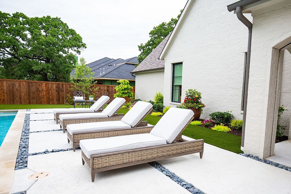 A row of lounge chairs lined up on a pool deck