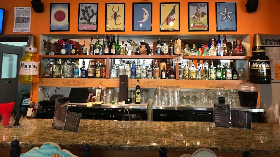 A bar with a lot of bottles on the shelves