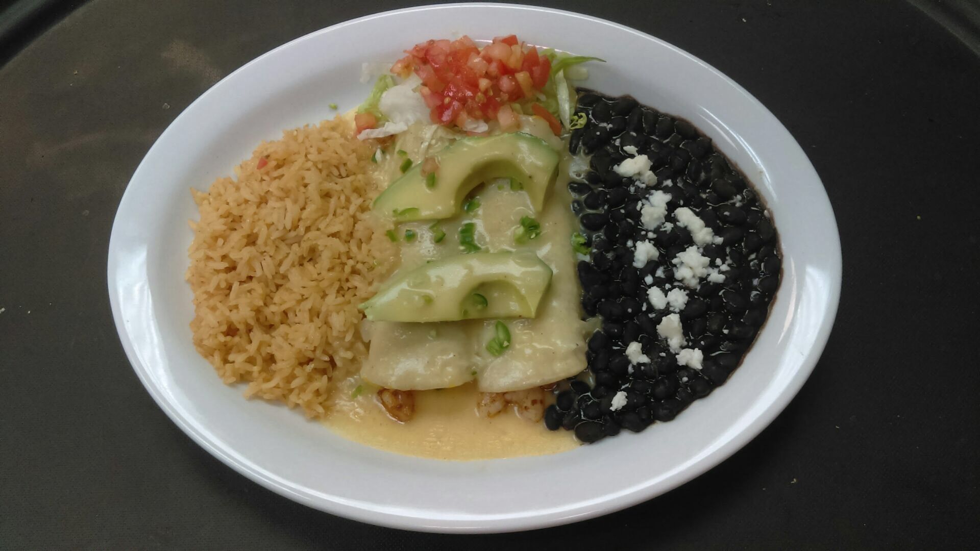 A plate of food with rice and black beans on a table.
