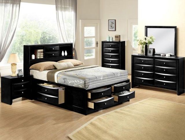A bedroom with a bed with drawers underneath it