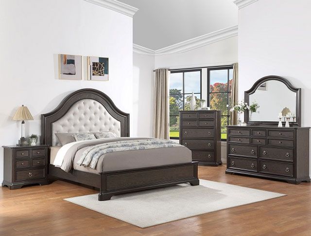A bedroom with a bed , dresser , nightstand and mirror.