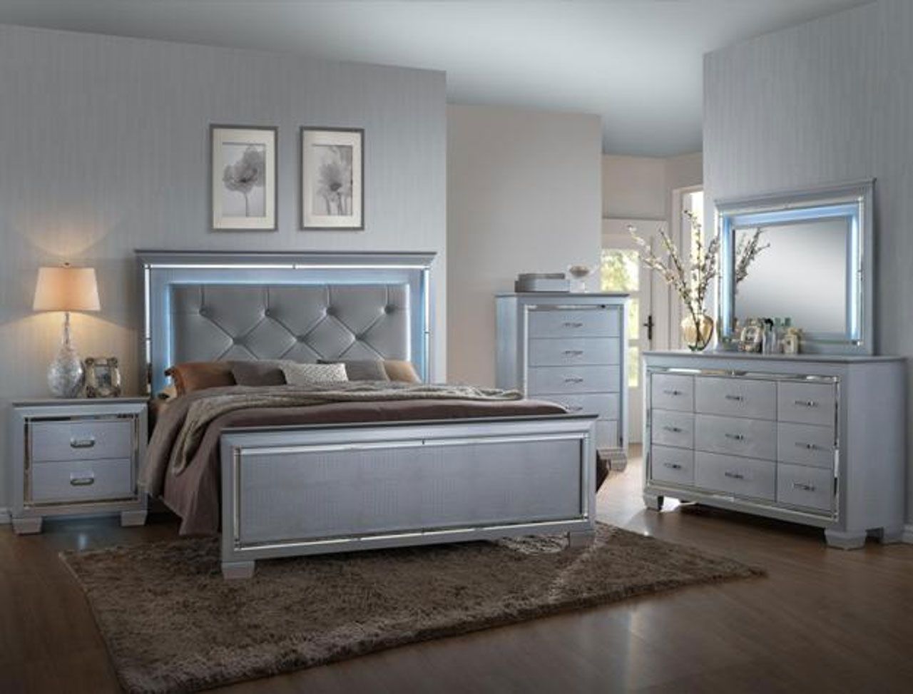 A bedroom with a bed , dresser , nightstand and mirror