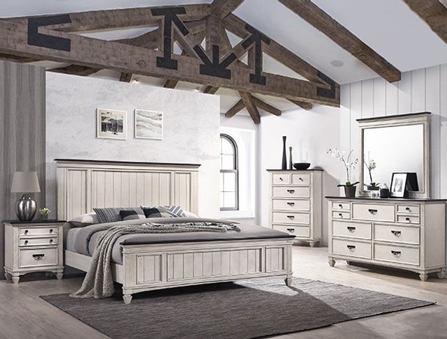 A bedroom with a bed , dresser , nightstand and mirror.
