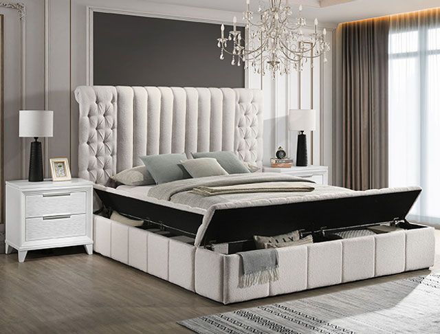 A bedroom with a bed , nightstand , and chandelier.