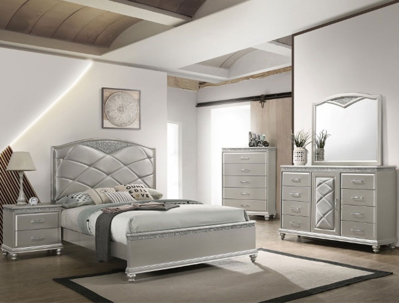 A bedroom with a bed , dresser , nightstand and mirror.