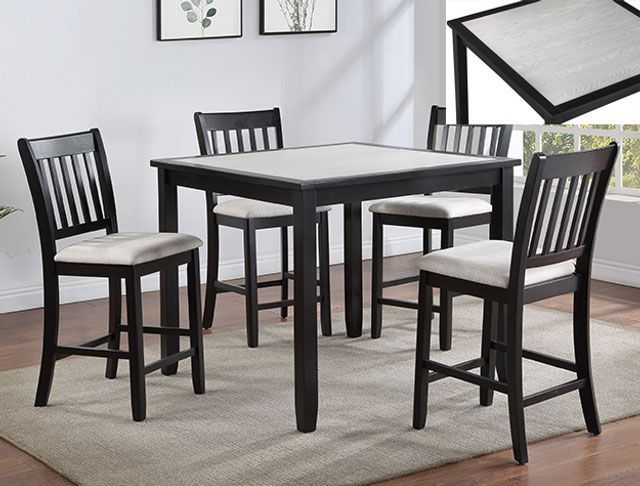 A dining room table with four chairs and a rug