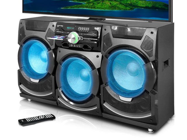 A remote control sits next to a speaker and a television