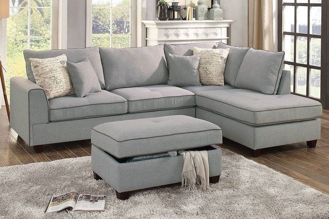 A living room with a sectional couch and an ottoman.