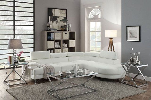 A living room with a white sectional couch and a coffee table.