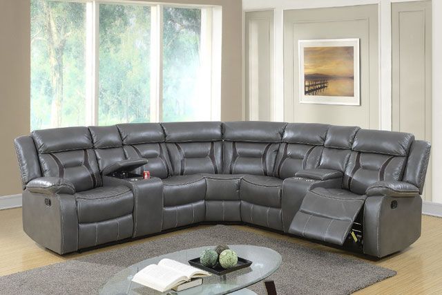 A living room with a gray sectional couch and a glass coffee table.