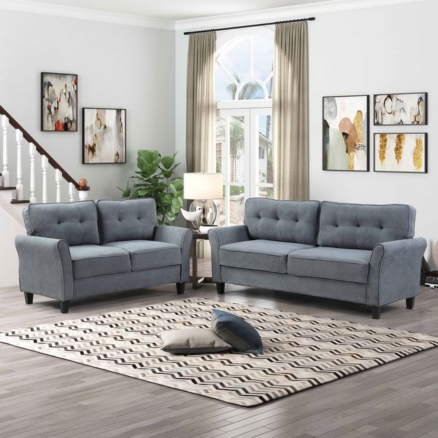 A living room with two grey couches and a rug