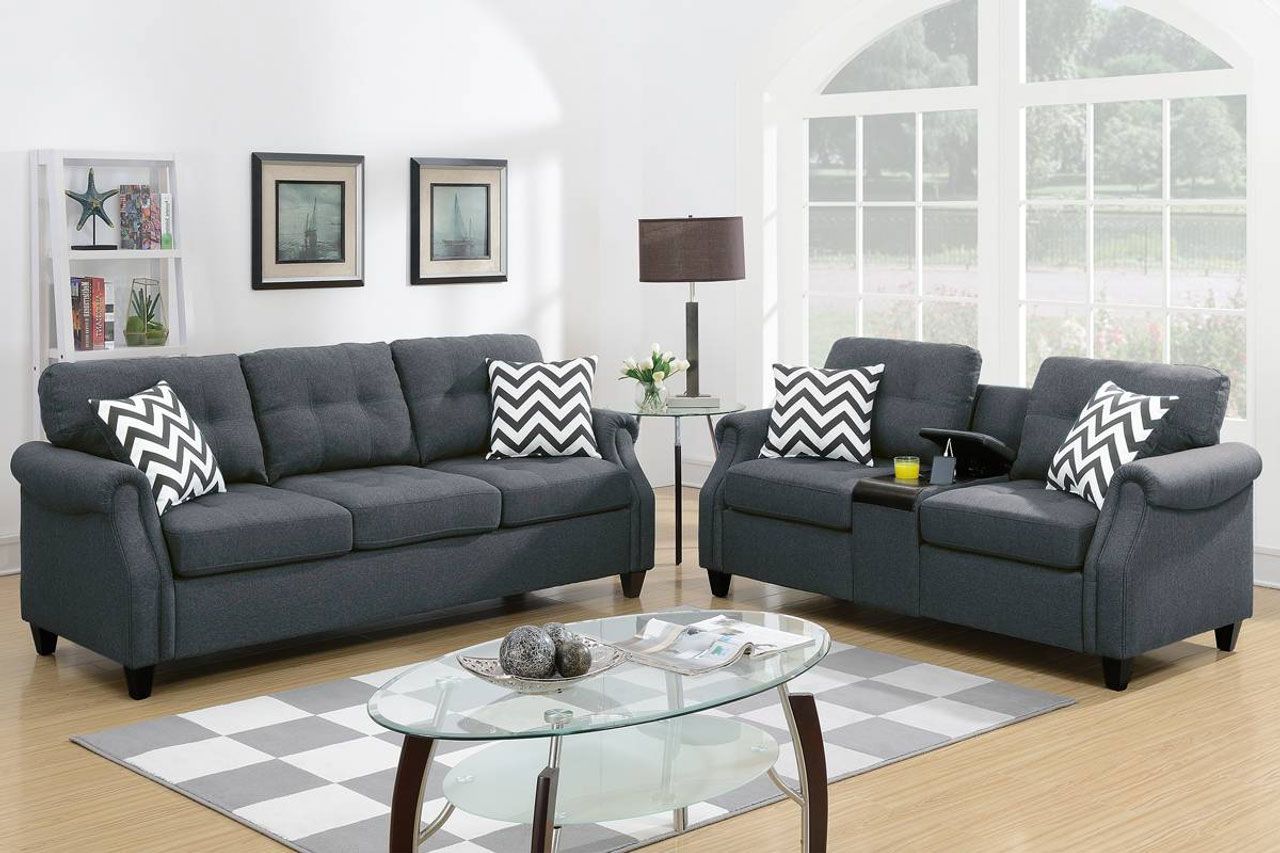A living room with two grey couches and a glass coffee table.