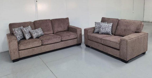 Two brown couches are sitting next to each other in a room.
