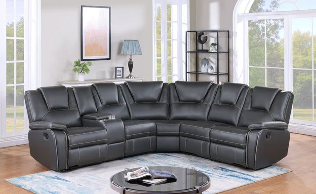 A living room with a black sectional couch and a coffee table.