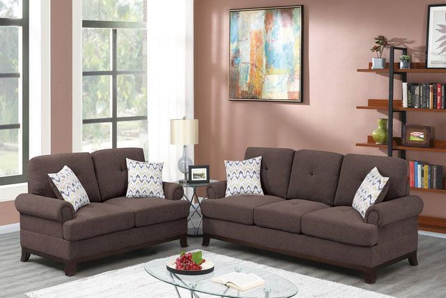 A living room with two brown couches and a glass coffee table
