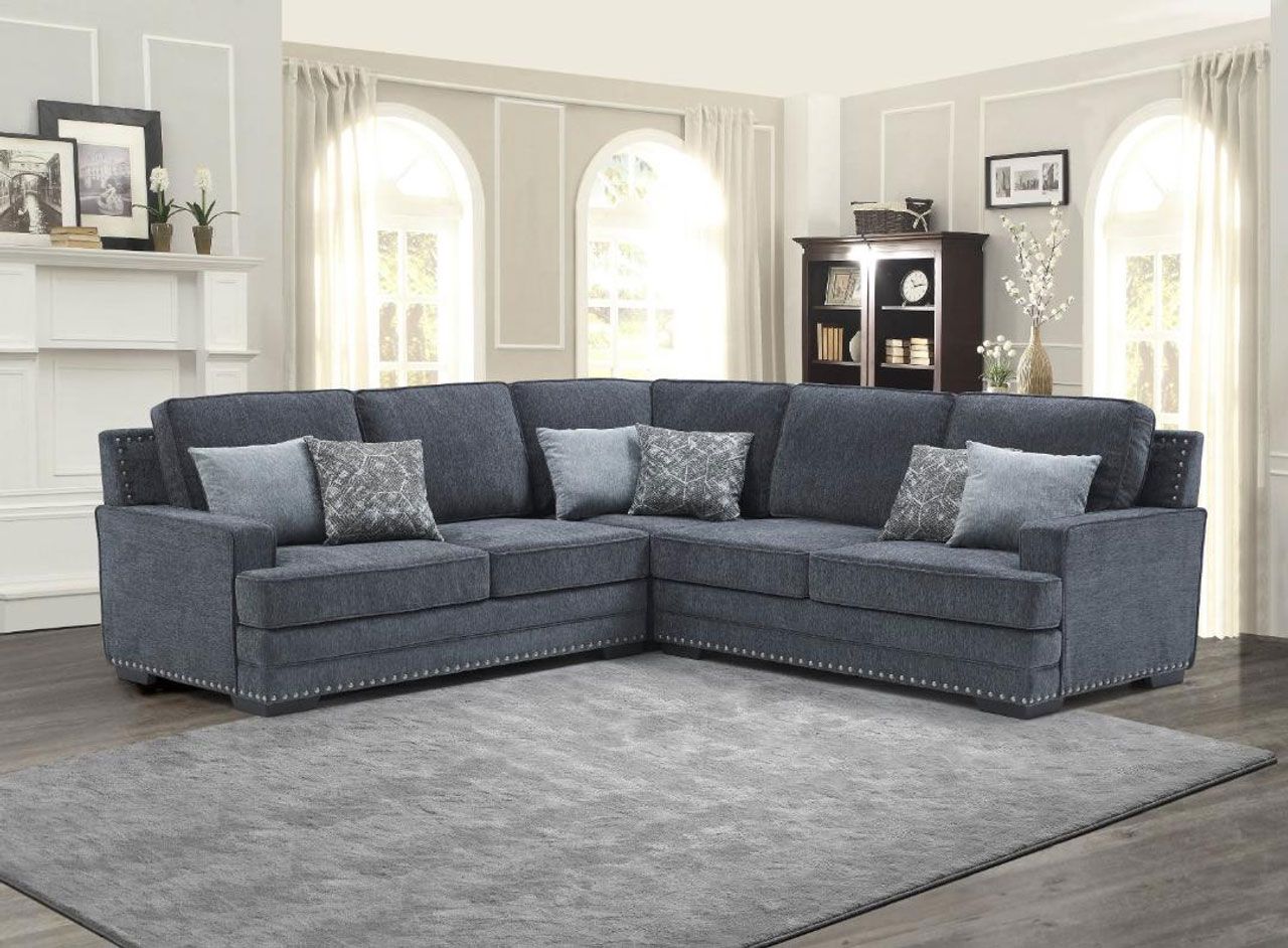 A living room with a large sectional couch and a rug.