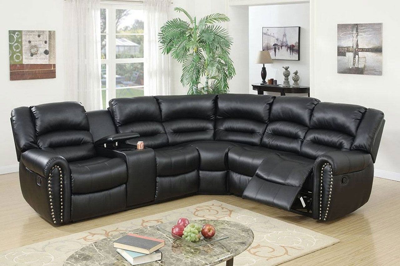 A black leather sectional couch is sitting in a living room next to a coffee table.