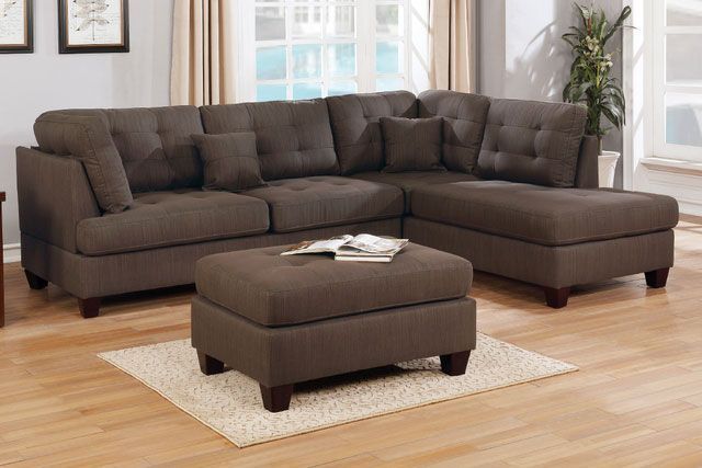 A living room with a sectional couch and an ottoman