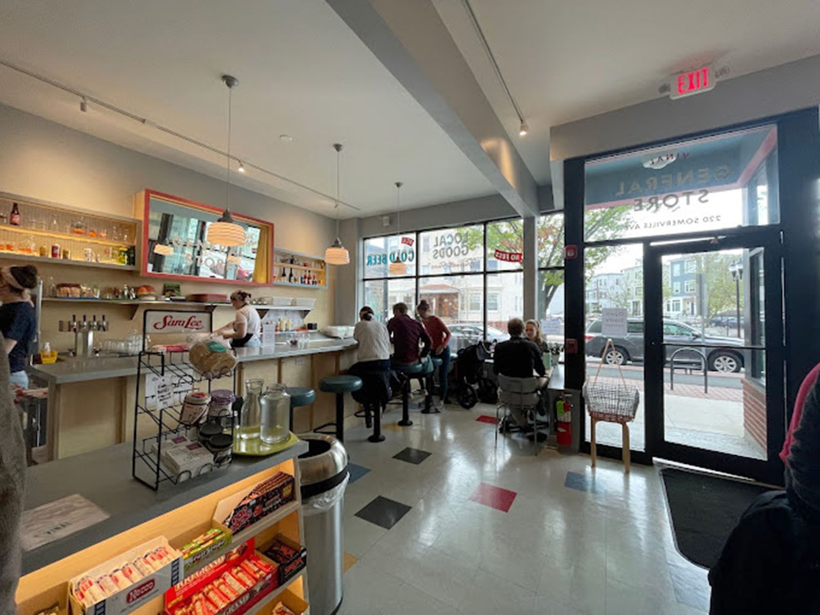 Interior of a store, with customers at a counter and tables