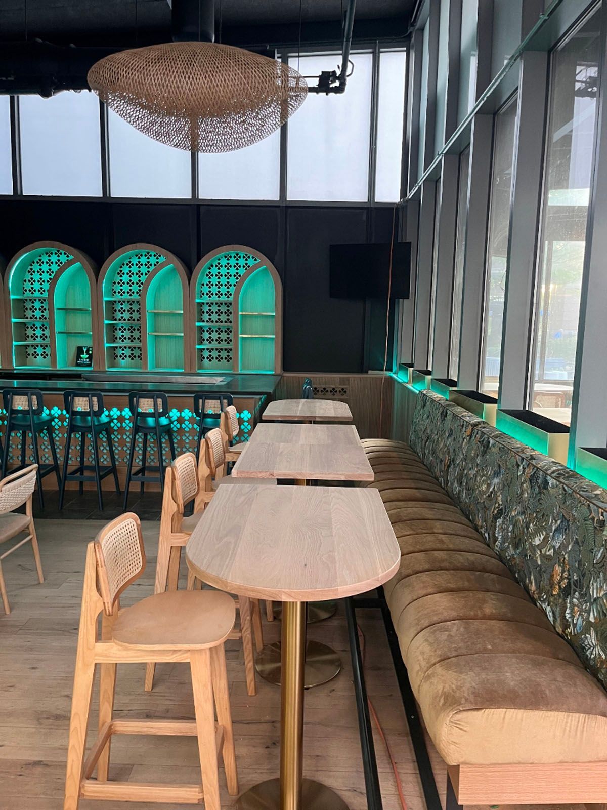 Restaurant interior with bar, tables, chairs, and cushioned booth seating