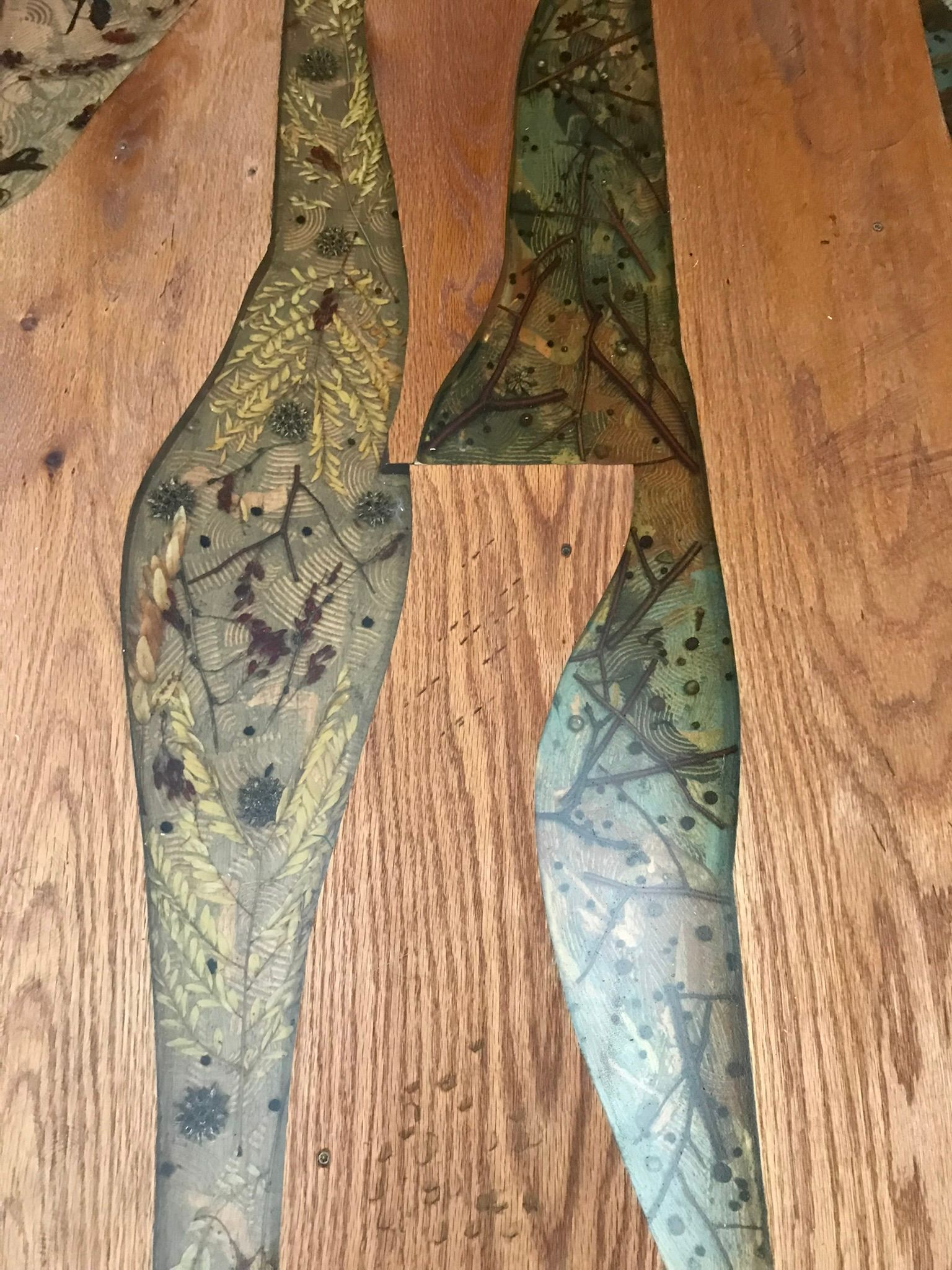 Wooden table with green and gold leaf design inlaid.