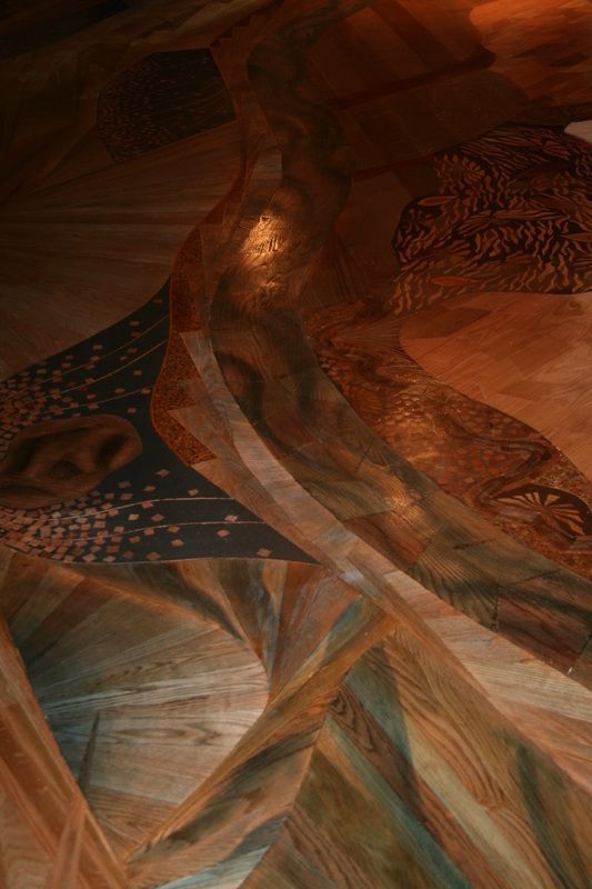 Abstract mural with warm brown and blue tones; possible figures and stars.