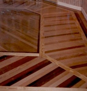 Wooden floor with geometric patterns and multiple wood tones.
