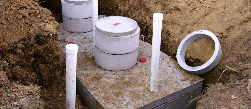 PVC pipes and fittings protruding from a concrete slab at a construction site