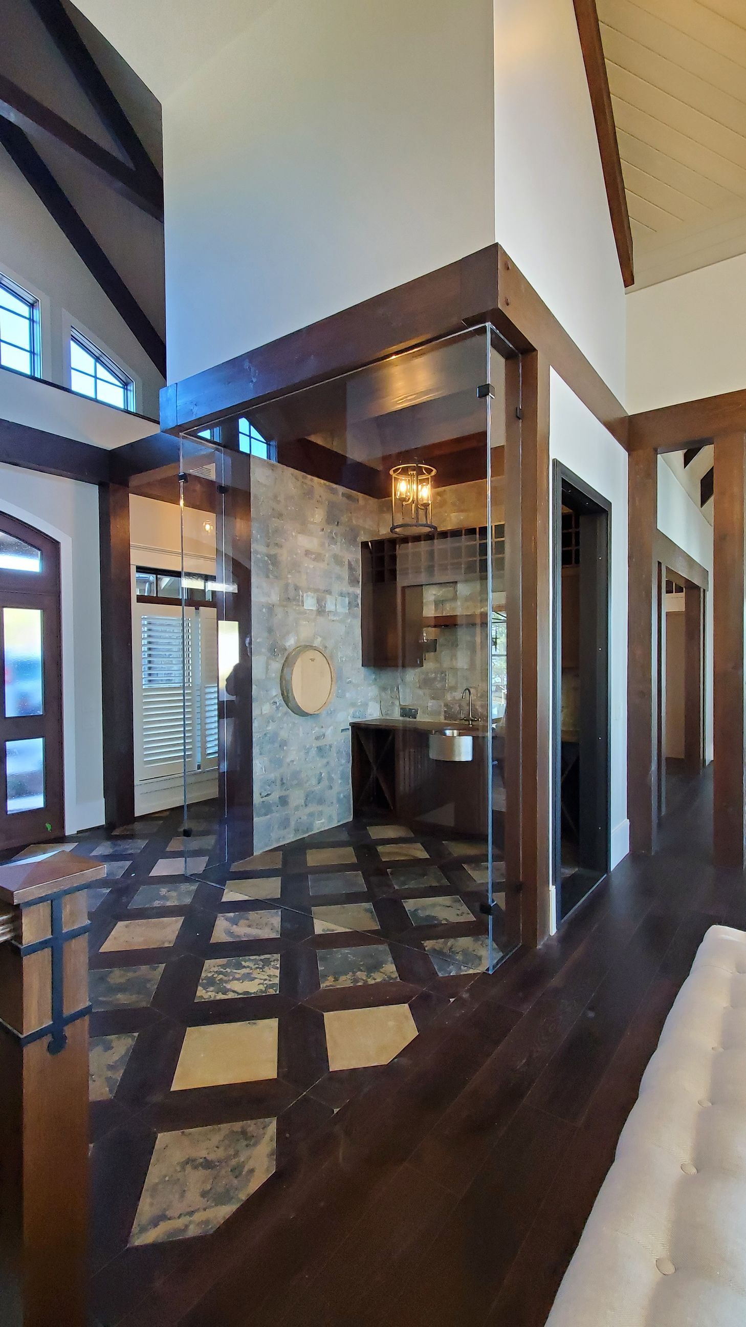 A living room with hardwood floors and a sliding glass door leading to a kitchen.