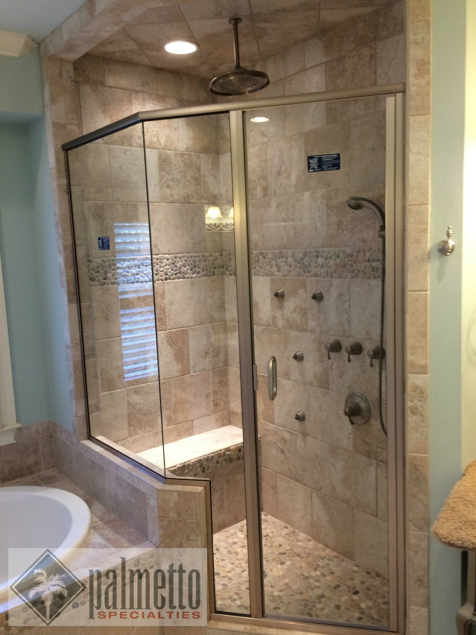 A bathroom with a walk in shower and a tub.