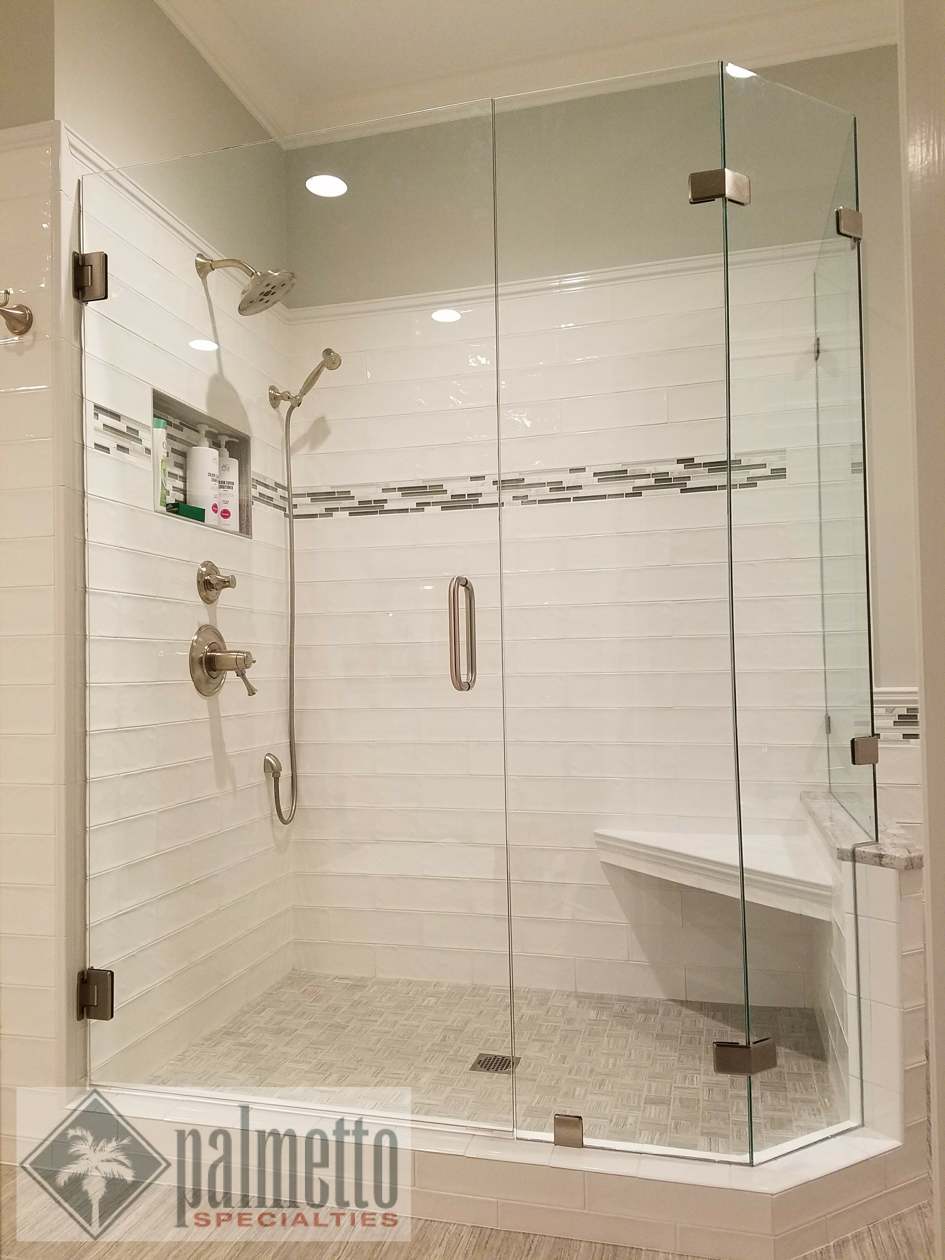 A bathroom with a walk in shower with a glass door.