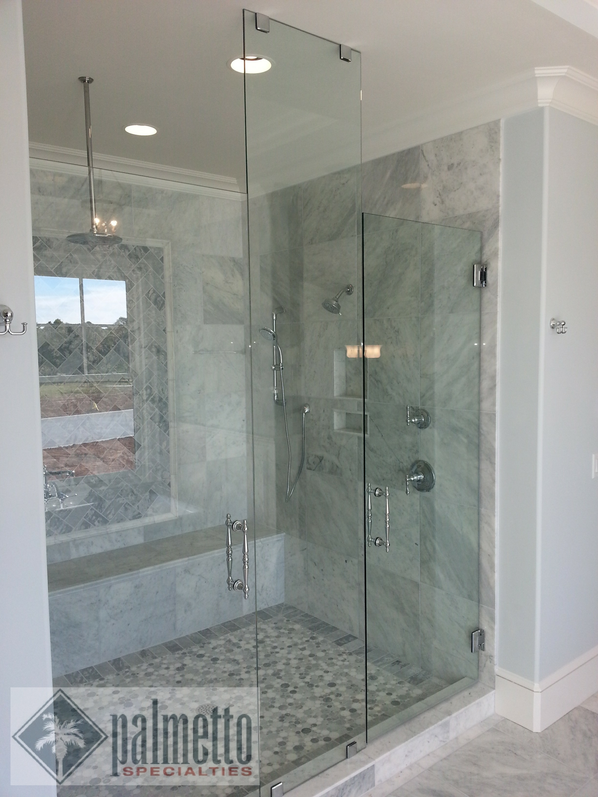 A bathroom with a walk in shower with a glass door