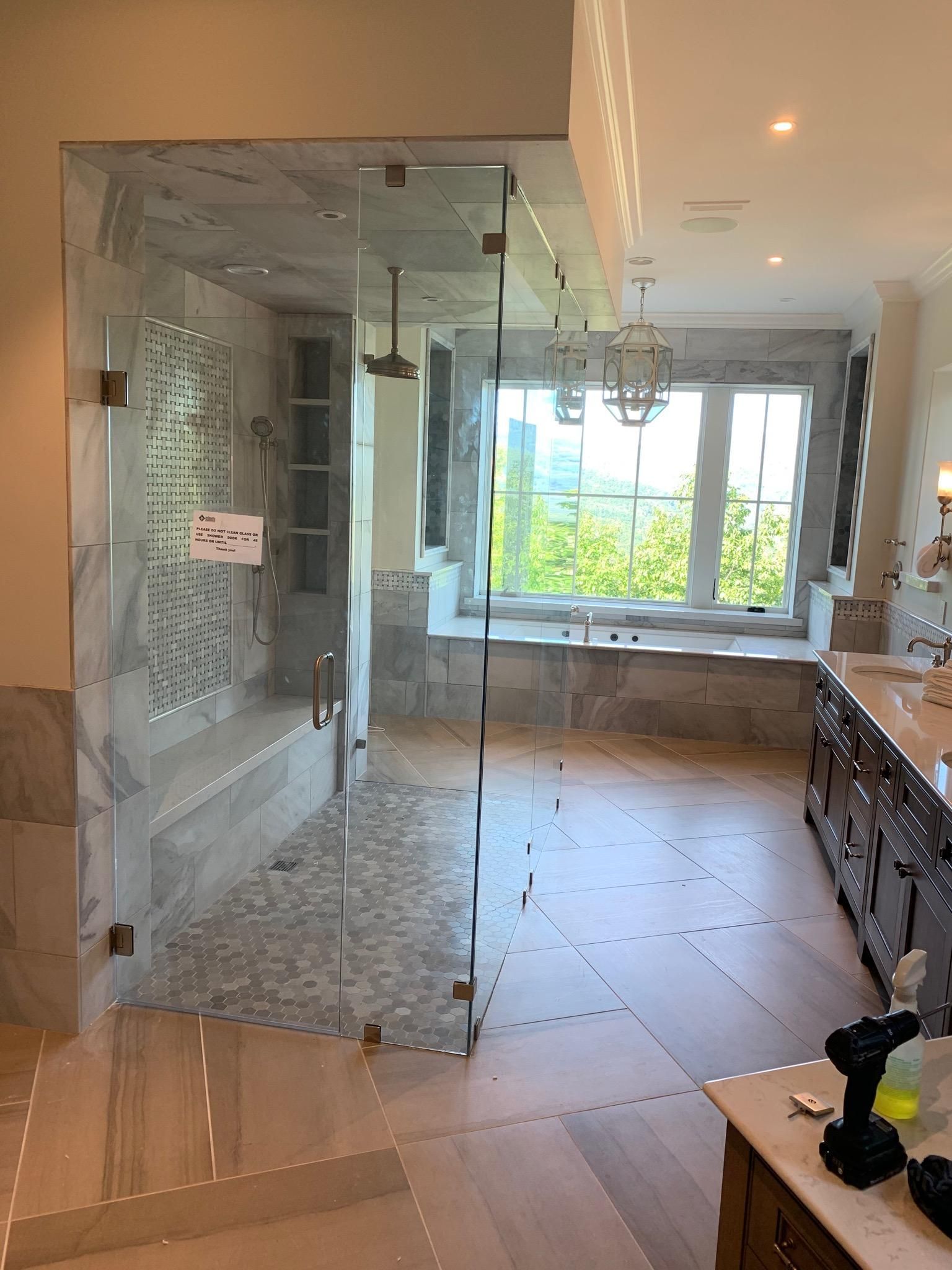A bathroom with a walk in shower and a bathtub.