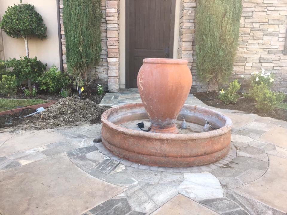 Concrete patio with peeling coating, black railing, and white columns.