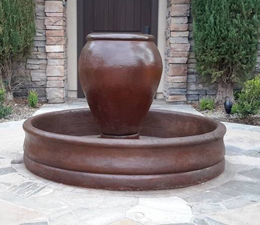 Bronze water fountain in a stone courtyard.