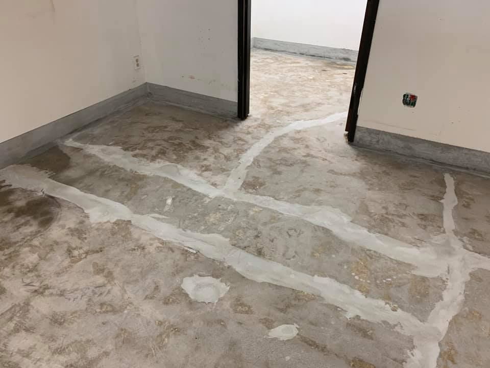 Gray concrete floor with white filler, doorway, and white walls.