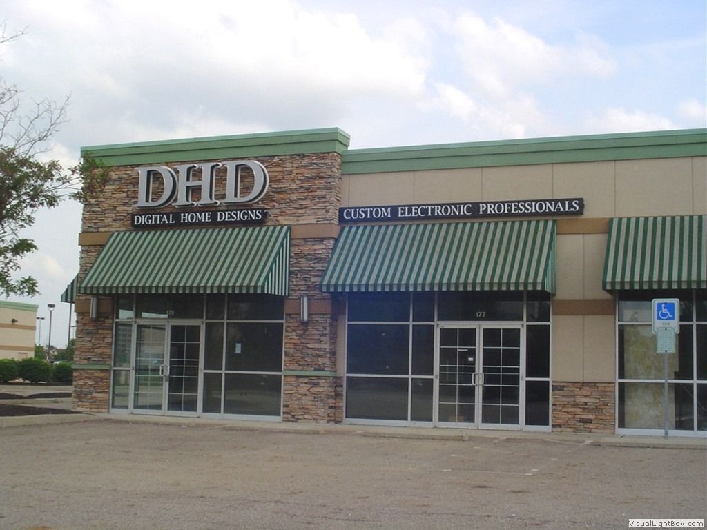 DAD Dental Implant Clinic storefront with green awnings.