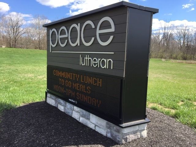 Sign for Peace Lutheran Church with digital display; gray and black colors, green grass background.
