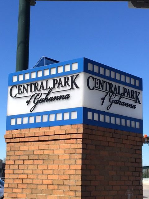 Sign for Central Park of Gahanna on a brick pillar, blue and white design with text.