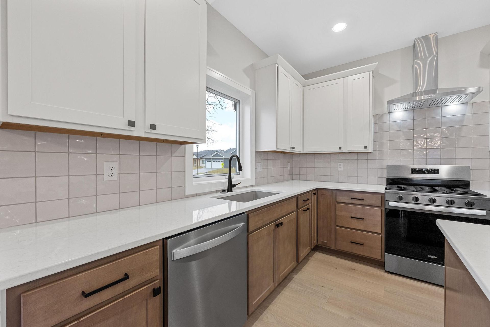 A kitchen with stainless steel appliances and wooden cabinets.