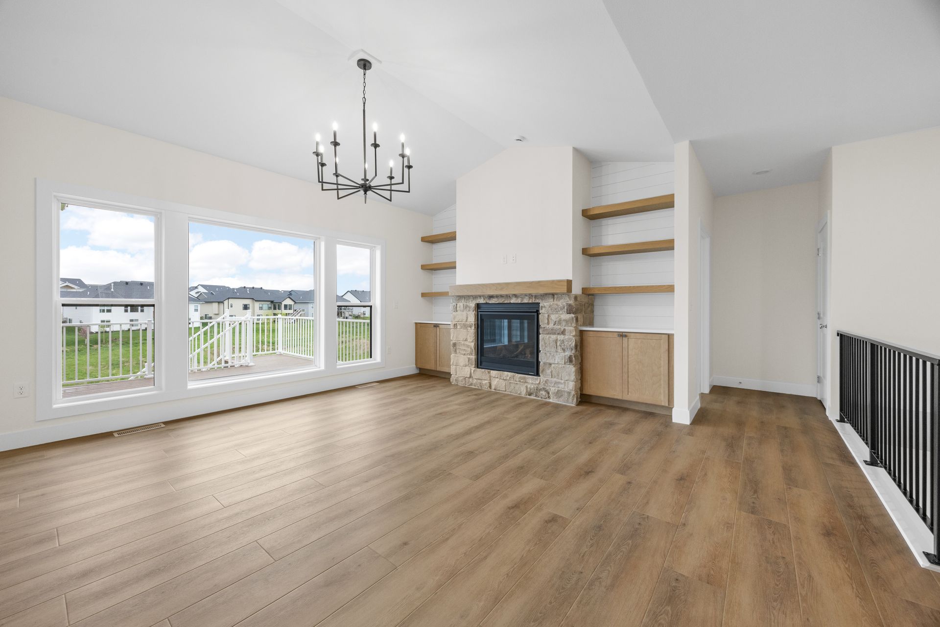 An empty living room with hardwood floors and a fireplace.