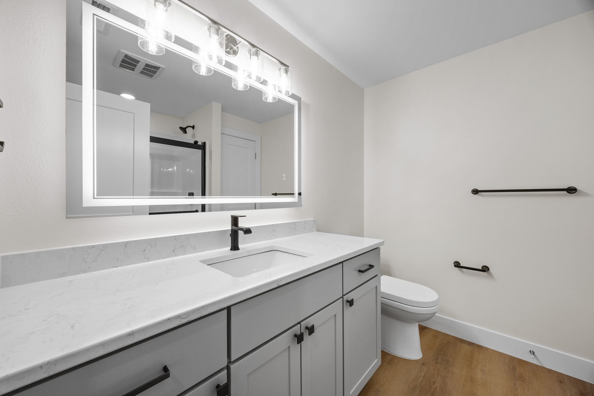 A bathroom with a sink , toilet and mirror.