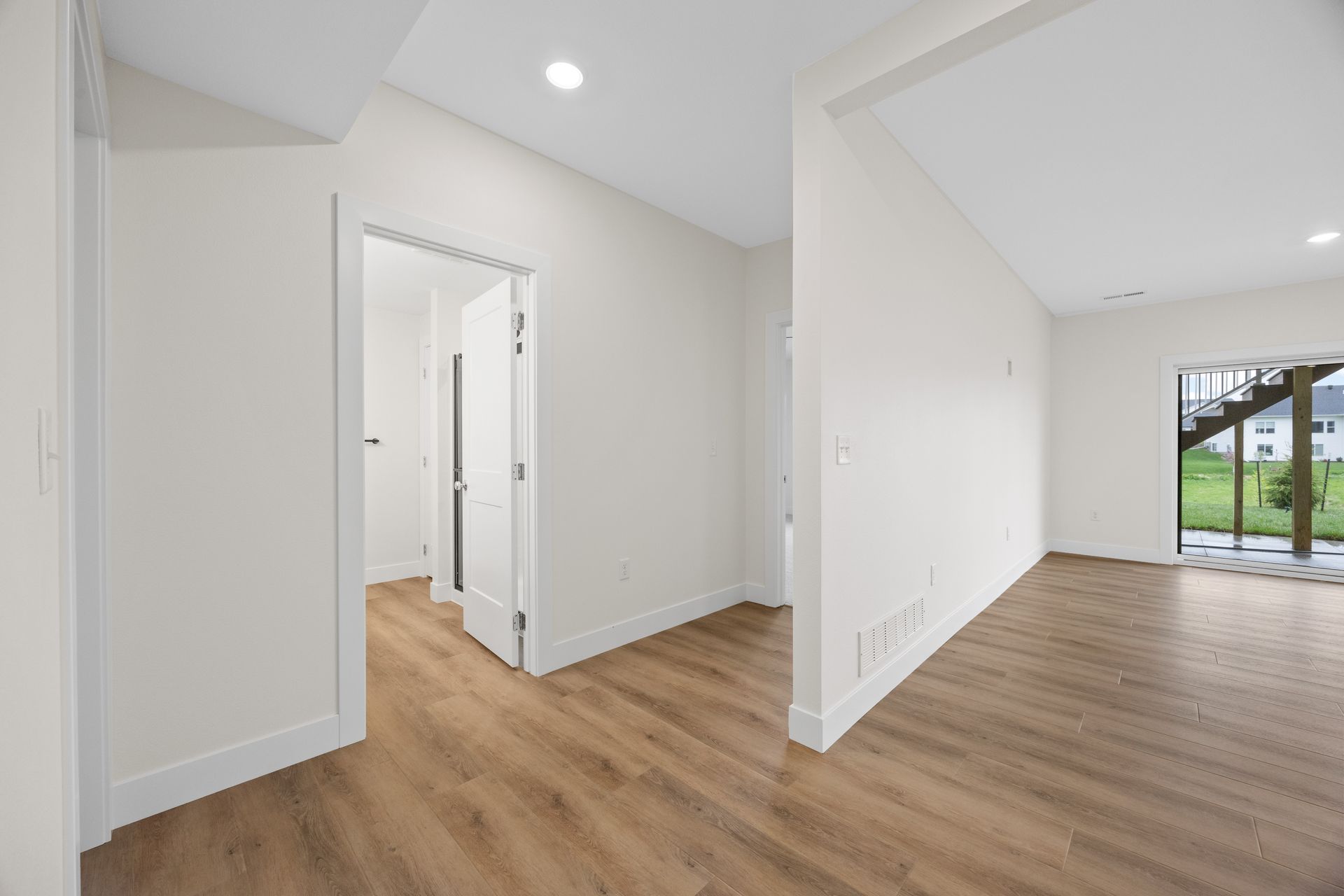 An empty room with hardwood floors and white walls.
