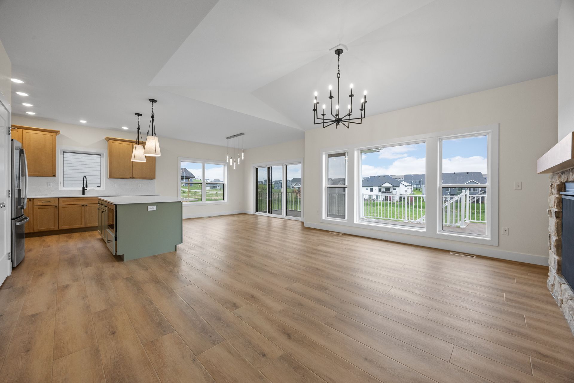 A large empty room with hardwood floors and a chandelier.